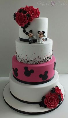 a three tiered cake with mickey and minnie mouse decorations