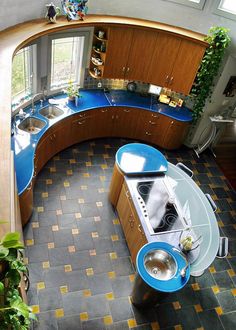 an aerial view of a kitchen with blue counters and tile flooring on the walls