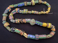 Antique Vintage Assorted Black, Green, & Yellow Fancy Skunk Millefiori  Venetian Lamp Work Trade Beads *19th-Early 20th Century *24" *52  beads total *These strands are not intended to be a ready-to-wear necklace; best for restringing on more durable thread *In very good, antique used condition from traveling 3 continents & aged over 100 years old with some signs of use & wear normal for these types of beads-small chips, corrosion, etc adding to their wonderful patina African trade beads originated from Europe and were used for trading purposes in Africa between the 16th century & early 20th century. Before the abolition of slavery, these beads were used by chiefs as currency in exchange for slaves, as well as incense, ivory, tortoiseshell, horn, oils, timber, iron, and other metals. Brigh African Trade Beads, Beaded Jewellery, Wear Necklaces, Trade Beads, 16th Century, Bead Necklace, Antique Vintage, 100 Years, Black Green