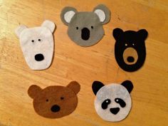 four felt animal heads sitting on top of a wooden table