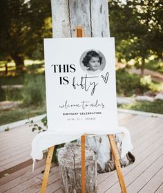 a sign that is on top of a wooden easel in front of a tree