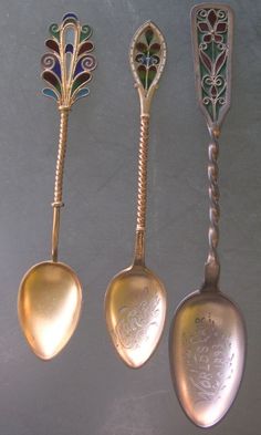 three antique spoons are sitting next to each other