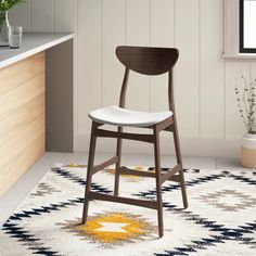 a wooden chair sitting on top of a rug in a kitchen next to a window