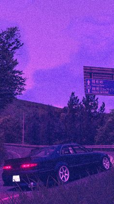 two cars are parked on the side of the road in front of a street sign