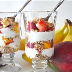 a glass jar filled with fruit and yogurt sitting on top of a table