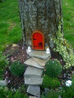 a tree with a red door and steps leading up to the base in front of it