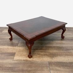 a wooden coffee table sitting on top of a hard wood floor