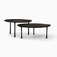 two black tables sitting next to each other on top of a white surface with no one in it