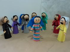 a group of dolls standing next to each other in front of a white wall,