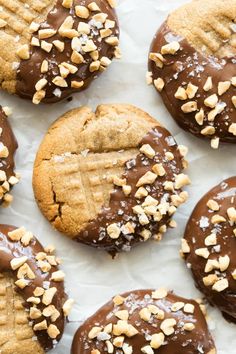 chocolate covered cookies with peanut butter and sea salt sprinkles on white parchment paper