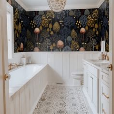 a bathroom with wallpaper and a chandelier hanging from the ceiling above it