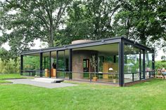 a glass house sitting on top of a lush green field