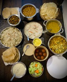 a table topped with bowls filled with different types of food next to tortillas