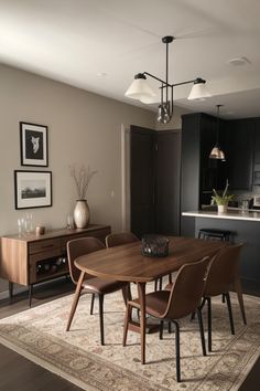 a dining room table and chairs in front of a kitchen