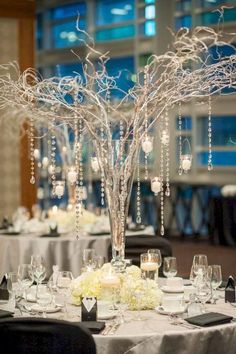 the centerpieces on this table are made from branches with candles and flowers in them