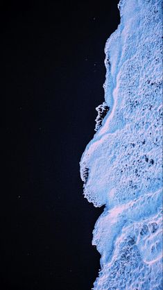 the snowboarder is flying through the air above the water's foamy shore