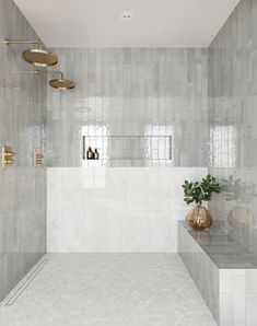 a white tiled bathroom with gold fixtures and plants in the window sill, on either side of the bathtub