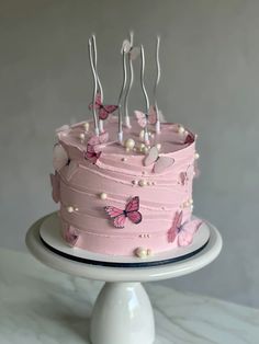 a cake with pink frosting and butterflies on it