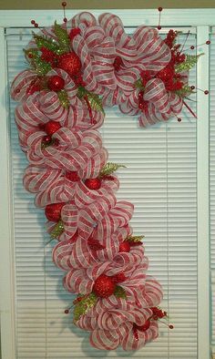 a wreath made out of candy canes and christmas decorations on a window sill