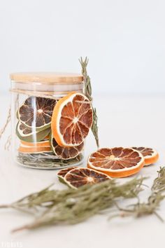 an orange cut in half sitting on top of a table next to some dried herbs