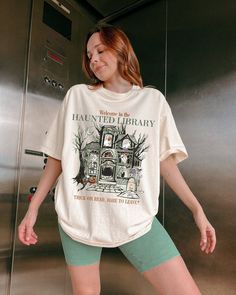 Countdown to Halloween with this exclusive Bookish Haunted Library Shirt. Perfect to be received as a thoughtful gift as well!  IMPORTANT (Please Read  Bookish merch exclusive from the Comfort Colors collection. .: 100% Cotton .: The soft-washed, garment-dyed fabric for an extra cozy feel. .: Medium fabric (6.1 oz/yd² (206.8 g/m .: Relaxed fit.  * CARE INSTRUCTIONS * ✺ Machine wash: cold (max 30C or 90F) ✺ Do not bleach. ✺ Tumble dry: Low heat. ✺ Iron, steam or dry: low heat ✺ Do not dry clean. * S I Z I N G * ✺ Please make sure to be accurate with your measurements before placing your order. For a more loose and comfortable fit, we suggest sizing up. * S H I P P I N G * T I M E S * ✺ Our items are individually made with love for each of our buyers. Delivery: Within 1 - 2 weeks (usually so Bookish Halloween, Bookish Shirts, Bookish Outfits, Job Clothes, Librarian Shirt, Reading Shirts, Book Shirts, Kinds Of Clothes, Teacher Shirts