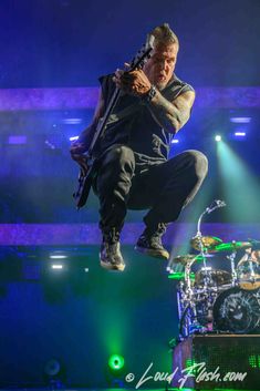 a man jumping in the air on top of a stage