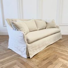 a white couch sitting on top of a wooden floor