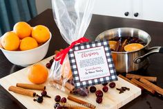 oranges and cinnamon sticks on a cutting board next to a bowl of cranberries