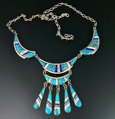 "This is one spectacular necklace!! It is such a flattering piece the way it drapes so beautifully on. The hook and open link chain give a lot a versatility in the wearable length and I have it hooked at difference lengths in each of my photos. The inlay clean and sharp with turquoise, lapis and either angel skin coral or spiny oyster. What I particularly love about the the turquoise in this, is that it has the natural matrix which you don't often see in inlay. This necklace is the kind of piece Unique Blue Turquoise Inlay Necklace, Southwestern Blue Necklace With Inlay, Southwestern Blue Inlay Necklace, Collectible Blue Inlay Necklace, Southwestern Style Blue Inlay Necklace, Southwestern Blue Turquoise Inlay Necklace, Native American Totem, Turquoise Squash Blossom, Angel Skin