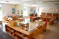 an empty classroom with wooden desks and benches in the center, filled with children's toys