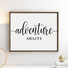 a white and black poster with the words adventure awaits in cursive font