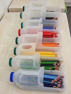 there are many different containers with pencils in them