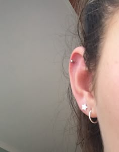 a close up of a person's ear with an earring in the shape of a star