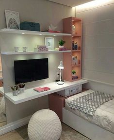 a bedroom with a bed, desk and tv on it's stand in the corner