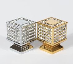 two gold and silver boxes sitting on top of each other, one is filled with diamonds