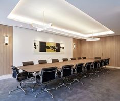 an empty conference room with black chairs and wood paneling on the walls is shown