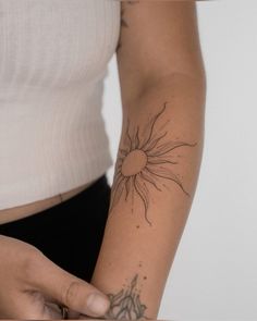 a woman with a sun tattoo on her arm