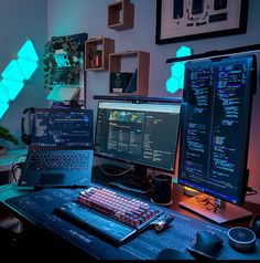 two computer monitors sitting on top of a desk next to a keyboard and monitor screen