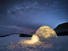 an igloose under the night sky with stars in the background and snow on the ground