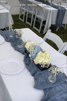 the table is set with white and blue flowers