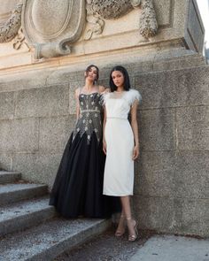 two women standing next to each other in dresses