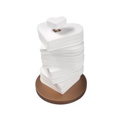 a stack of white paper sitting on top of a wooden stand