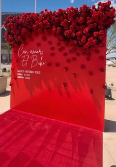 a large red sign with flowers on it