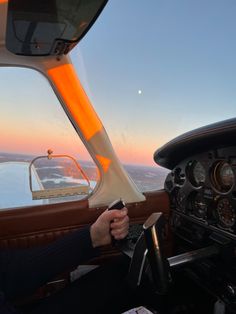 a man is sitting in the cockpit of an airplane with his hand on the steering wheel