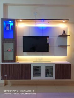 the entertainment center is built into the wall with blue lights on it's sides