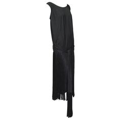 A transformative dress with a fetching shirred cummerbund that cups the tush and 2-foot fringe that never stops moving. Begs for a headpiece, garter flask and dance partner. Sleeveless flapper dress with plunging back, pintuck shoulders and scalloped drop waist; attached draped cummerbund-pleated sash with extra-long front tails. 24” silk fringe from waist to hemline with modesty panel behind; 13” fringe at sash ends. Pullover construction with no closures except two hooks and eyes to keep sash Shimmy Dress, Floral Print Gowns, Runway Gowns, Beaded Party Dress, 1920s Outfits, Long Sleeve Evening Gowns, Velvet Cocktail Dress, Jeanne Lanvin, Printed Gowns