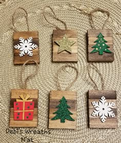 christmas ornaments made out of wooden blocks with snowflakes and stars on them, sitting on a woven place mat