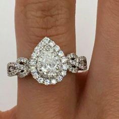 a woman's engagement ring with an oval shaped diamond in the center and two rows of diamonds on each band