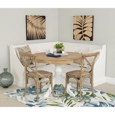 a dining room table with two chairs and a potted plant