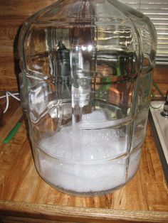 a large glass container filled with water on top of a wooden table